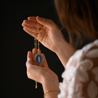 lady holding up the virgin of Guadalupe Reina medallion